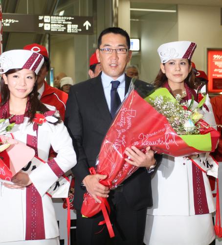広島の野村監督（中央）は沖縄に到着し空港で花束を受け取る