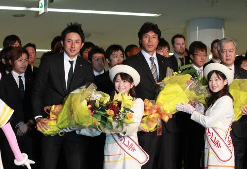 ＜ソフトバンク宮崎入り＞宮崎空港に到着し宮崎サンシャインレディより歓迎の花束を受け取る川崎選手会長（左）と秋山監督（左から２人目）