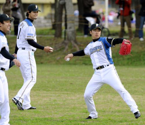 キャンプインし、キャッチボールする日本ハムの斎藤佑樹投手（右）。左奥はダルビッシュ有投手