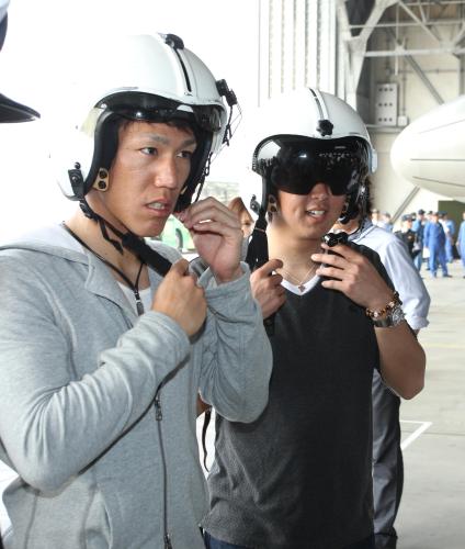 海上自衛隊那覇航空基地を訪れ、ヘルメットを装着する須田（右）と荒波