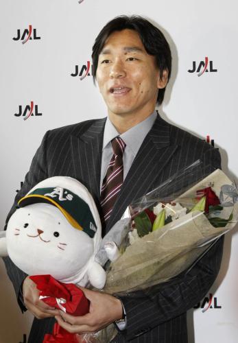 アスレチックスの帽子をかぶった日本航空のキャラクターを手に、報道陣の質問に答える松井秀喜外野手