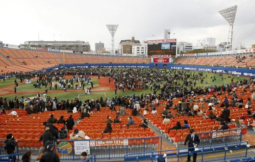 プロ野球のオープン戦の横浜―ヤクルトで、地震のためグラウンドに避難した選手や観客ら＝11日午後、横浜スタジアム