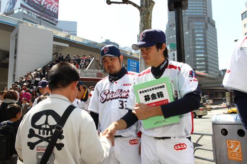 ヤクルトナインは渋谷駅前で募金活動を行い、由規も募金箱を持って対応