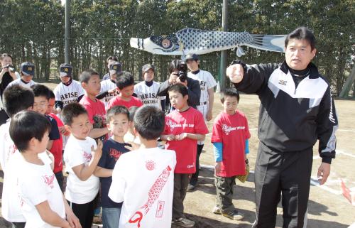 集団避難している双葉町の子供たちにボールの握り方を教える小早川氏