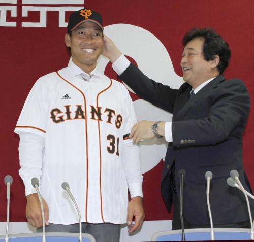 入団記者会見で笑顔を見せる巨人・高橋信。右は清武英利球団代表