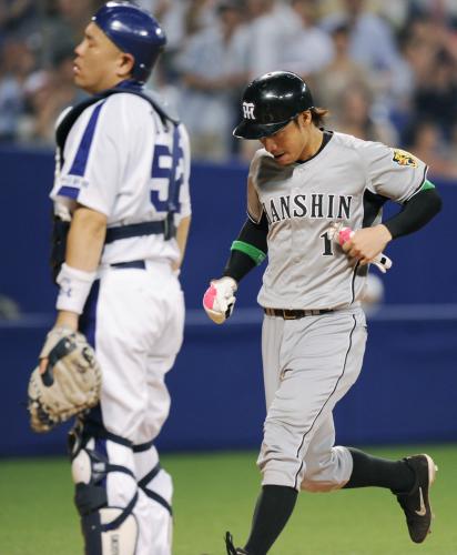 １１回阪神無死二塁、マートンの右前打の返球を捕手小田（左）がエラー、先制の生還をする鳥谷