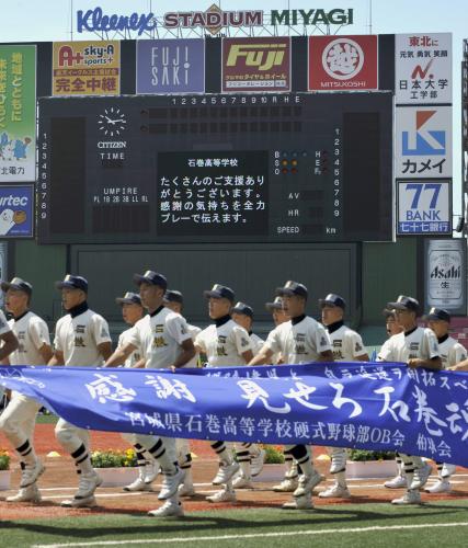 全国高校野球選手権大会宮城大会の開会式で、横断幕を掲げて入場行進する石巻高ナイン