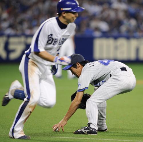 ５回中日無死一塁、岩崎達（左）のバント処理に手間取る横浜・大原慎。この後一塁に悪送球
