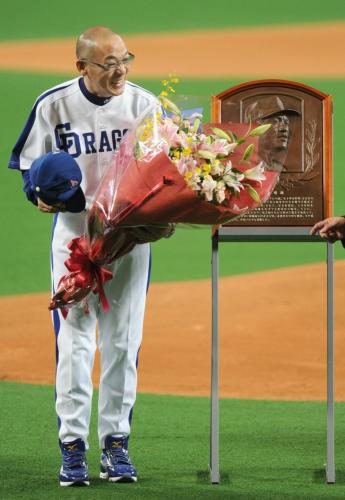 試合前に行われた野球殿堂入りの表彰式で、花束を手に笑顔を見せる中日の落合監督