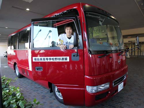 マイクロバスの運転席で笑顔を見せる和田