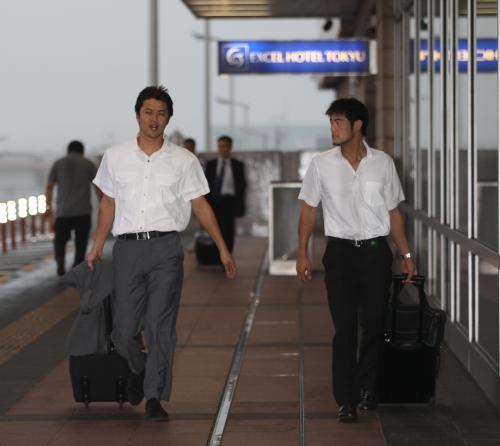 悪天候の中、羽田空港に到着した金子誠（左）と飯山