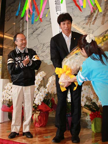 孫オーナー（左）が拍手をする中、花束を受け取る秋山監督