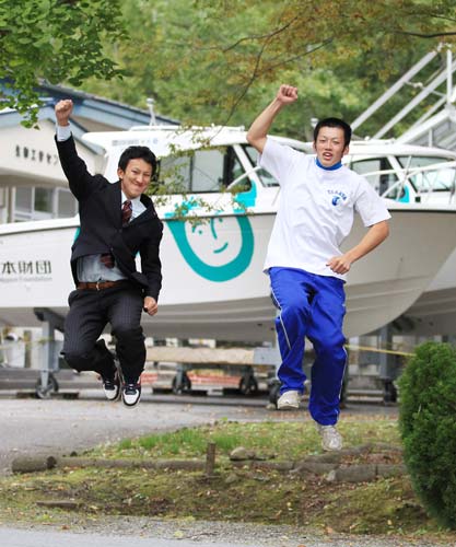 航海士を目指す大和田寿（右）と仙台大に進学する木村は仮校舎内に置かれたボートの前で地元復興へ決意を新たに