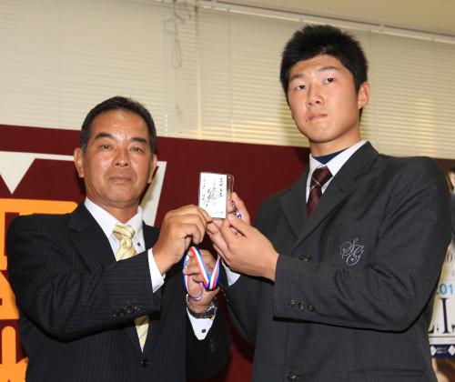 阪神２位指名の聖光学院高・歳内は、中尾スカウト（左）から「エースになれ！」と書かれた和田監督のメッセージを手渡される