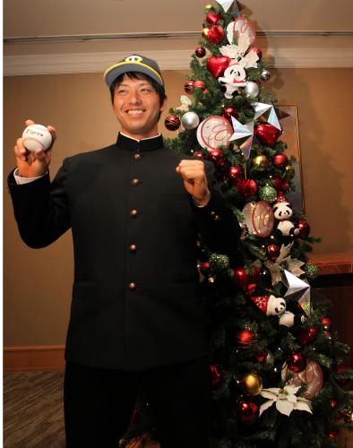 ＞阪神のボールを手にクリスマスツリーの前で笑顔の伊藤
