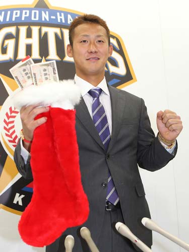 契約更改を終えた中田はおもちゃの札束を手にポーズをとる