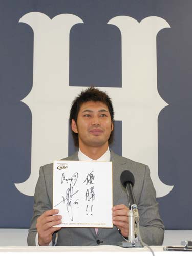 契約更改を終え、来季の目標を書いた色紙を手に記者会見する広島・栗原