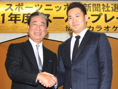 スーパープレー大賞を受賞し、星野監督（左）と握手をかわす田中