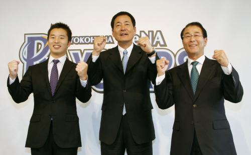 横浜ＤｅＮＡの初代監督に就任し、笑顔でポーズをとる中畑清氏（中央）。左は池田純球団社長、右は高田繁ＧＭ
