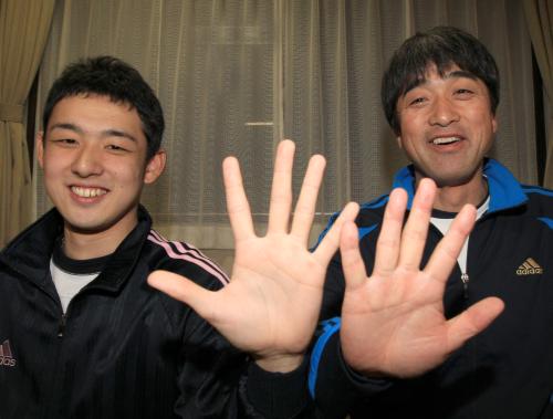 早大に合格した大志さん（左）と手の大きさを比べる高田高校の佐々木監督。いつの間にか大きさは抜かされてしまった