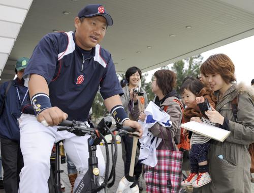 大勢のファンに囲まれ、自転車で移動する中日・山崎