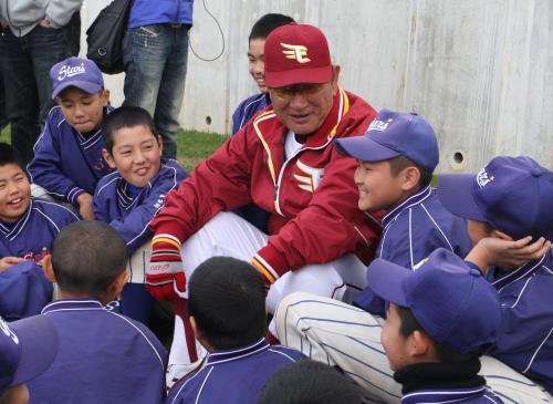 少年野球チームの子供たちに囲まれて笑顔で話をする星野監督