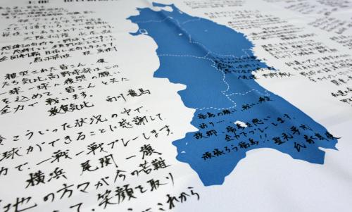 東北の地図が描かれた布に書き込まれた応援メッセージ