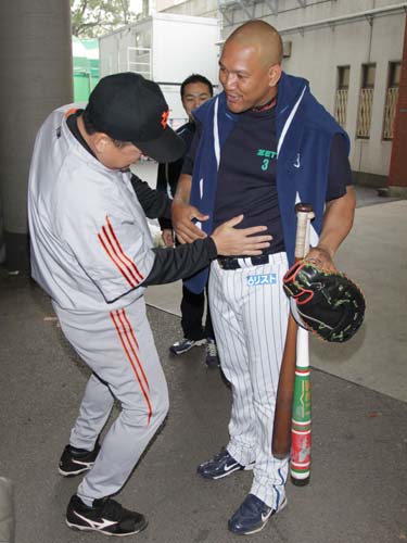 巨人・江藤コーチ（左）にお腹を触られるＤｅＮＡ・ラミレス