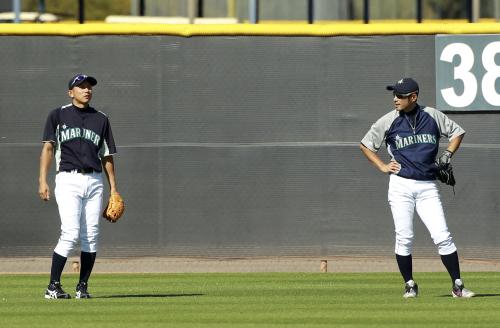 打撃練習の後、外野で話すマリナーズのイチロー（右）と川崎