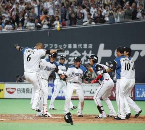 ＜日・楽＞９回、サヨナラ本塁打を放ちナインに迎えられる日本ハム・中田（左端）