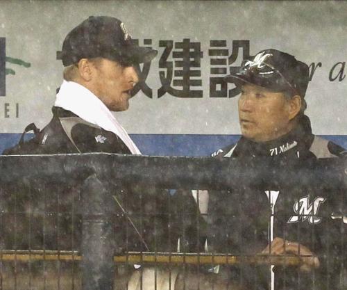 雨天中止となり、ベンチで西本投手コーチ（右）と話すロッテのグライシンガー