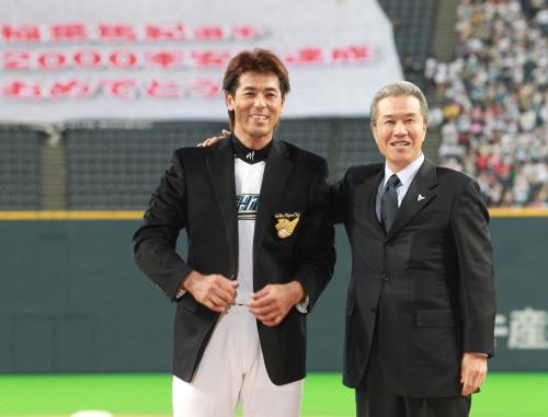 ＜日・Ｄ＞試合前、山田氏（右）に名球会のブレザーを着せてもらい、笑顔の日本ハム・稲葉