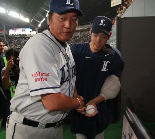 ＜日・西＞試合後、渡辺監督（左）と握手する西武・菊池