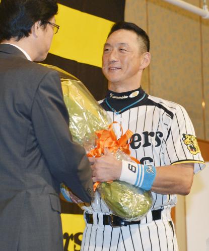 記者会見で引退を表明し、南信男球団社長から花束を受け取るプロ野球阪神の金本知憲外野手