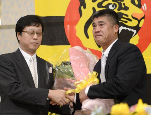 現役引退を表明し、南信男球団社長（左）から花束を受け取る阪神・城島