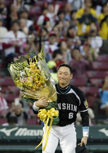 試合前のセレモニーで、花束を手にスタンドのファンにあいさつする阪神・金本