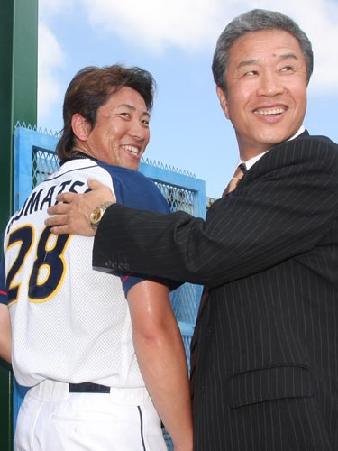 ０９年、ＷＢＣ日本代表コーチとして視察に訪れ小松の背番号「２８」をなでる山田久志氏