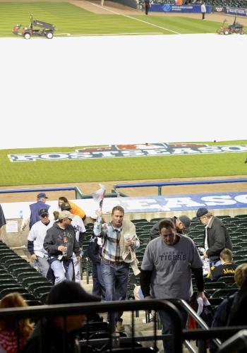 ヤンキースとの第４戦が悪天候のため中止となり、シートで覆われたグラウンドを背に球場を後にするタイガースのファン