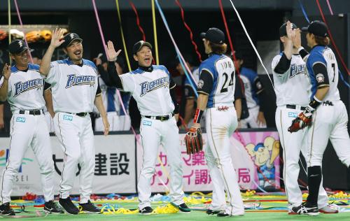 ３年ぶり６度目の日本シリーズ進出が決まり、笑顔でナインを迎える日本ハム・栗山監督（左から３人目）