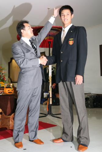 指名あいさつを終え握手をかわす阪神・和田監督（左）は藤浪の長身ぶりにビックリ