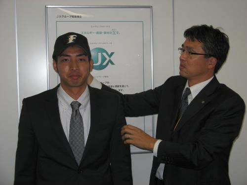 仮契約を終え大渕スカウト（右）から日本ハムの帽子をかぶせてもらったドラフト６位・屋宜