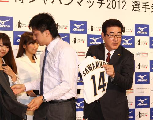 沢村（左）にユニホームを渡す前、沢村栄治氏と同じ背番号「１４」を披露する山本監督
