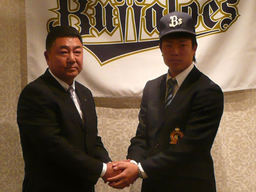 オリックスと仮契約を結び、長村編成部長（左）と握手を交わす大体大・松葉