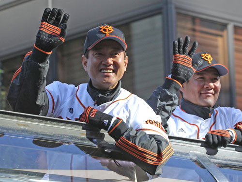 沿道のファンに手を振る巨人・原監督。右は斎藤コーチ