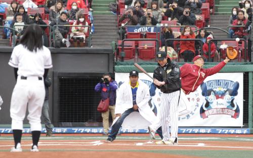 牡鹿中・佐藤瑞保さん（左）の始球式の球に飛びつく捕手・嶋（右端）。打者の新井貴（右から２人目）は空振り、球審はウィジャヤナーヤカさん