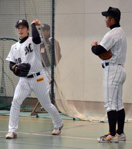高校球児に投球フォームの指導をするロッテの藤岡貴裕投手（左）
