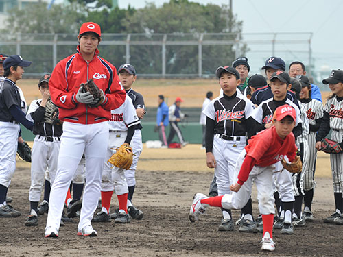 少年野球チームの投手にアドバイスする広島・野村
