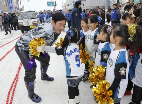 北海道栗山町で行われた優勝パレード出発前に、子どもたちに祝福される日本ハム・栗山監督