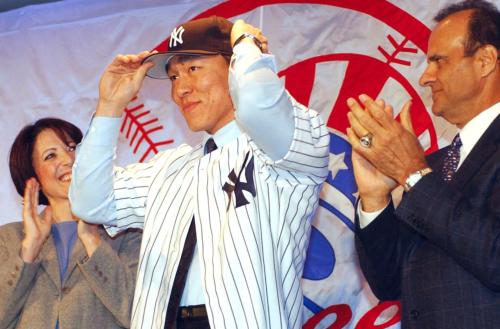 ２００３年１月、ヤンキースへの入団会見で、ユニホームを着て帽子をかぶる松井秀喜外野手。右はトーリ監督