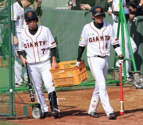 バント練習の後、仲良くかごを持ってマシンの中にボールを入れる巨人の長野（左）と坂本